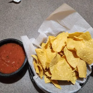 a basket of chips and a bowl of salsa