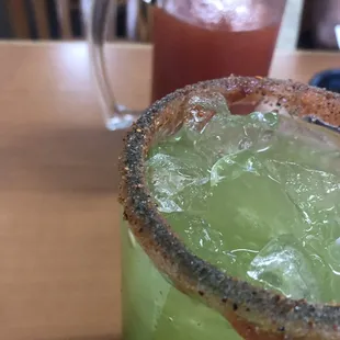 Michelada in the background and a cucumber lime water in the foreground. Both large drinks.