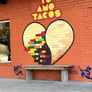 a bench in front of a brick building
