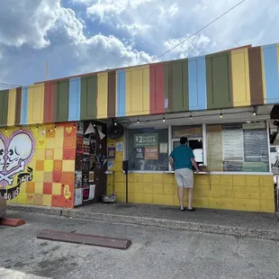 a man standing in front of a colorful building
