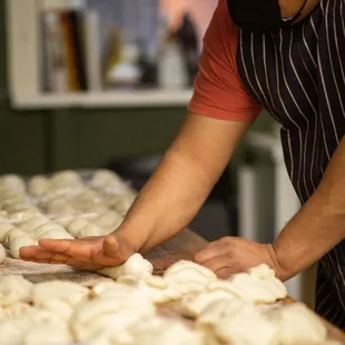 a man wearing a face mask preparing doughnuts