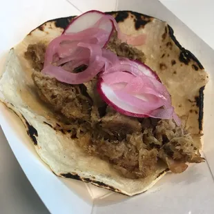 a tortilla with meat and onions