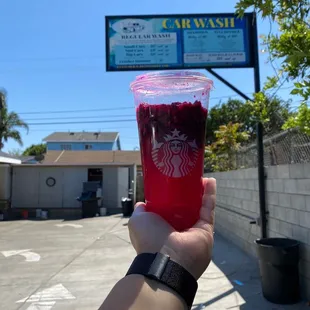 a hand holding a cup of juice