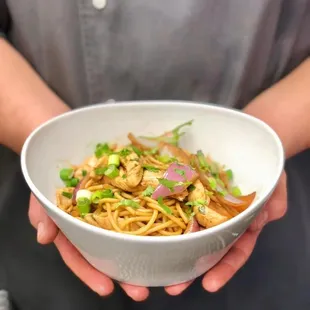 a person holding a bowl of food