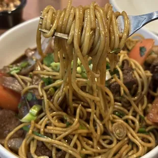 a bowl of noodles with meat and vegetables