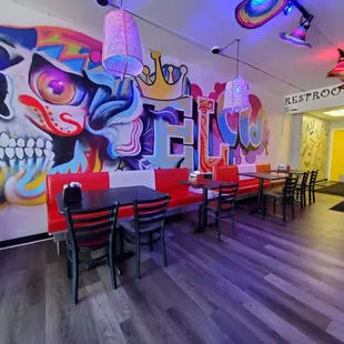 a restaurant with a colorful mural on the wall