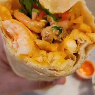 a hand holding a burrito