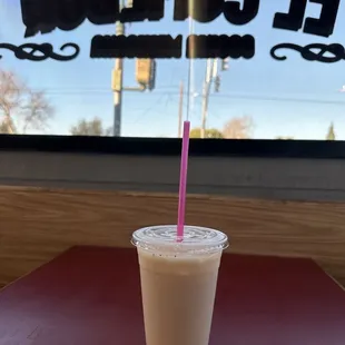 a drink in a plastic cup with a pink straw