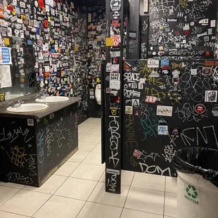 a bathroom with graffiti on the walls