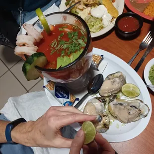a plate of oysters and a bloody drink