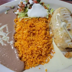 Steak chimichanga, cheese sauce, rice beans and salad