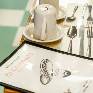 a place setting with a menu and silverware