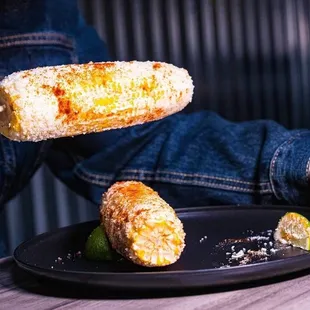 a person eating corn on a stick