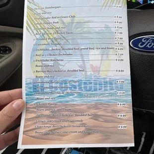 a hand holding a menu