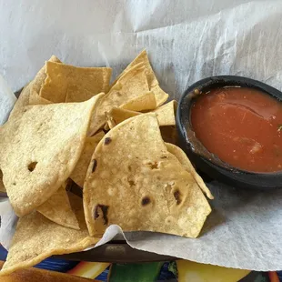 a bowl of salsa and tortillas