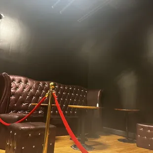 a brown leather couch and a red rope