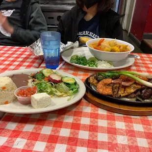 This is the Salvadoran churrasco, which is grilled shrimp, tasty and tender steak and chicken with traditional salad and rice and beans