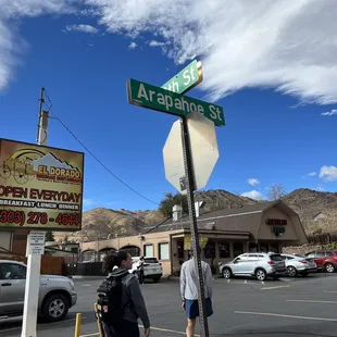 two people standing under a street sign