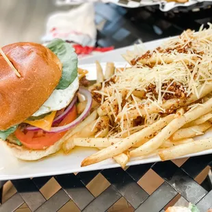 Vegetarian burger with slices of avocado, fried eggs and garlic fries