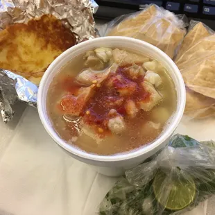 Small menudo to go. They give you onions, cilantro and lime in the bag and clips and bread with butter too.