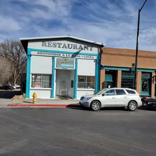 a white car parked in front of a restaurant