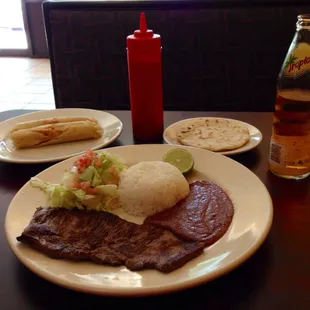 a plate of steak, rice, and salad