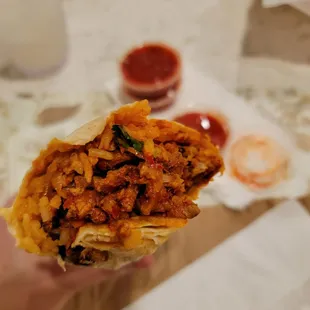 a person holding a burrito