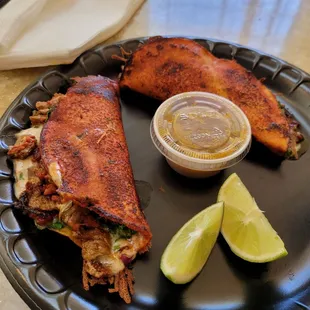 a plate of food with a side of lime wedges