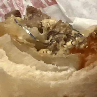 Steak and egg burrito, with a diver strand of inedible material. Looks like part of a scouring pad.