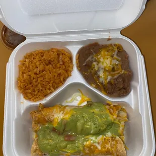 Three road tacos with sour cream, guacamole, and beans and rice