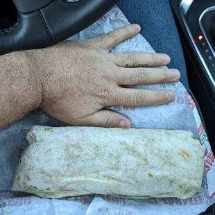 a person holding a burrito