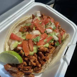 Adobada taco. It's big and loaded with guacamole sauce and pico. Very good and filling.