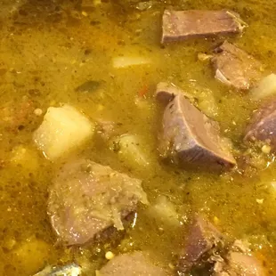 a pot of soup with meat and potatoes