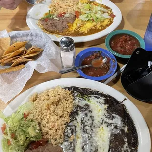 Cheese and chicken mole enchiladas served with rice and refried beans