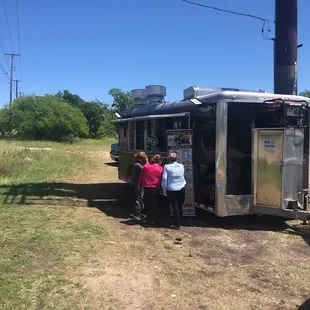 a group of people standing in front of a food truck