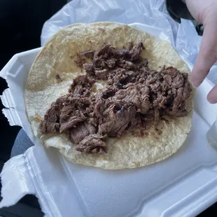 a hand grabbing a tortilla