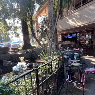 Outdoor patio, pond &amp; waterfall behind railing.