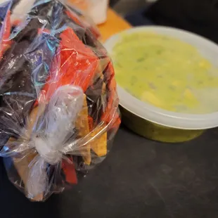 a bag of chips and a bowl of dip