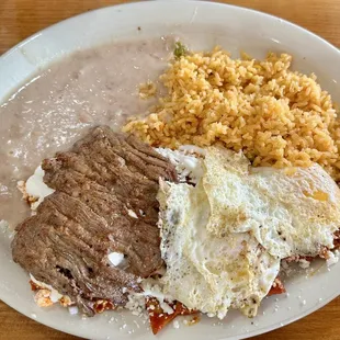 Chilaquiles topped with skirt steak and eggs.