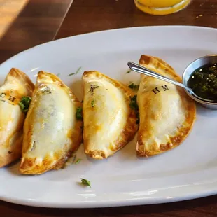 Variety of empanadas (stamps tell you what's inside) and side of chimichurri