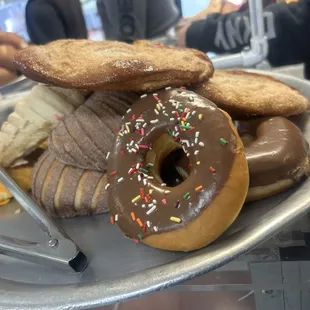 a tray of donuts with chocolate frosting and sprinkles