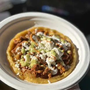 Sopes: corn dough layered with beans, lettuce, protein of choice, sour cream and queso fresco.