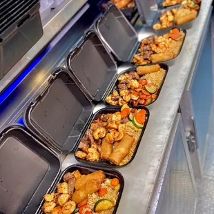 a line of trays of hotdogs