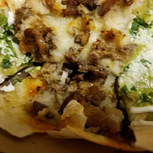Inside of quesadilla, with bits of chicken, pastor, and asada.