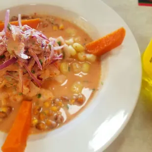a bowl of soup with carrots and corn