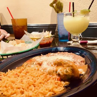 A chili Relleno, Mexican refried beans, and Mexican rice with a large frozen margarita.