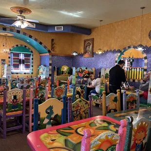 a restaurant with brightly colored tables and chairs