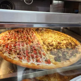 two pizzas in a display case