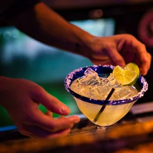 a person holding a margarita