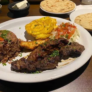 Carne asada, gallo pinto, queso frito, tostones y ensalada de repollo.